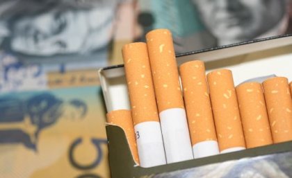 Open packet of cigarettes with $A50 note in the background.
